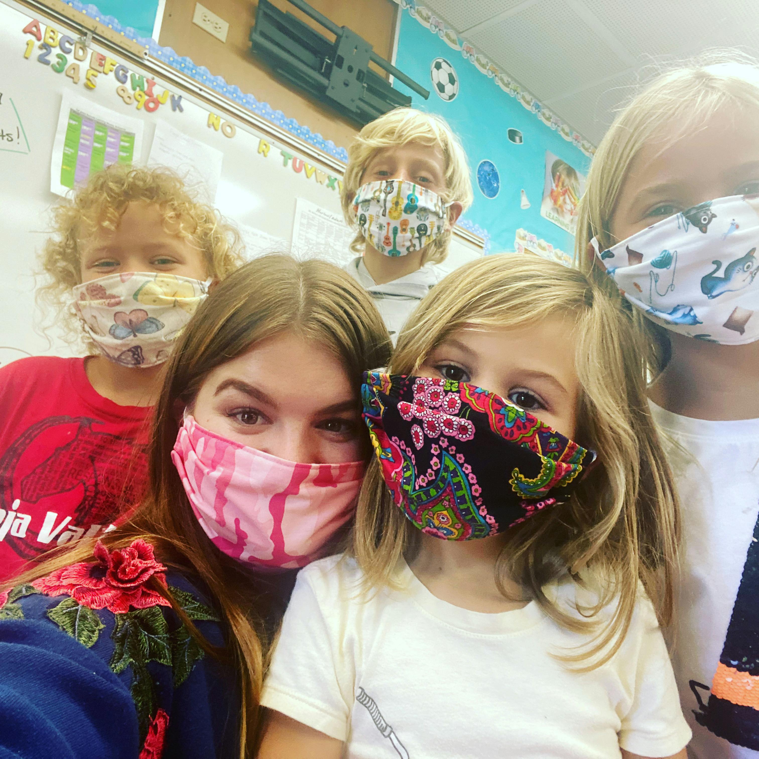 Group of children and teens wearing face masks in a classroom