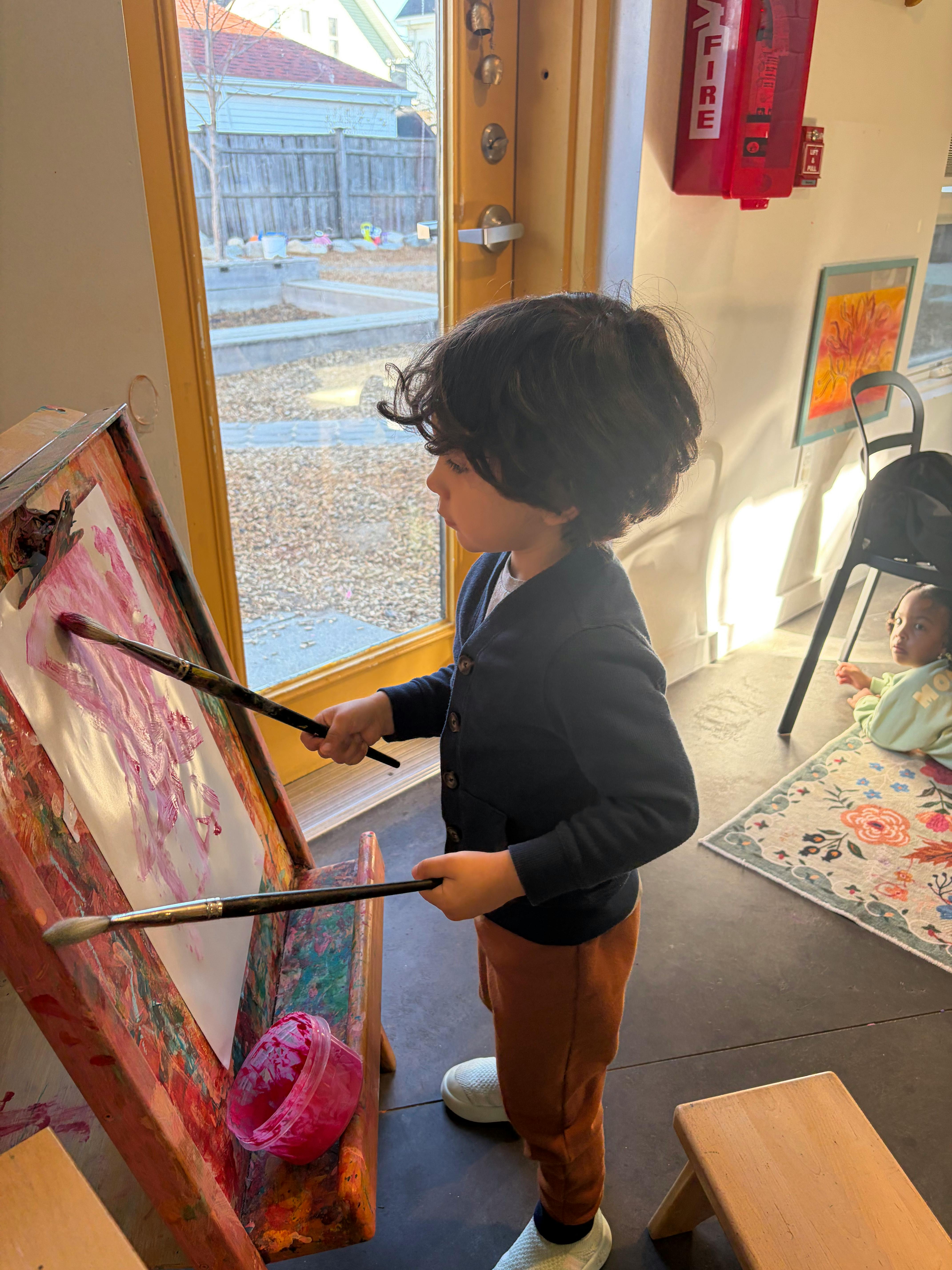 Child painting on paper at an easel