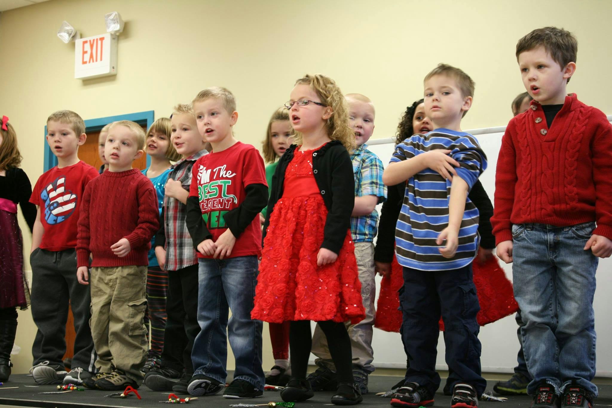 Group of children standing in a line, some singing