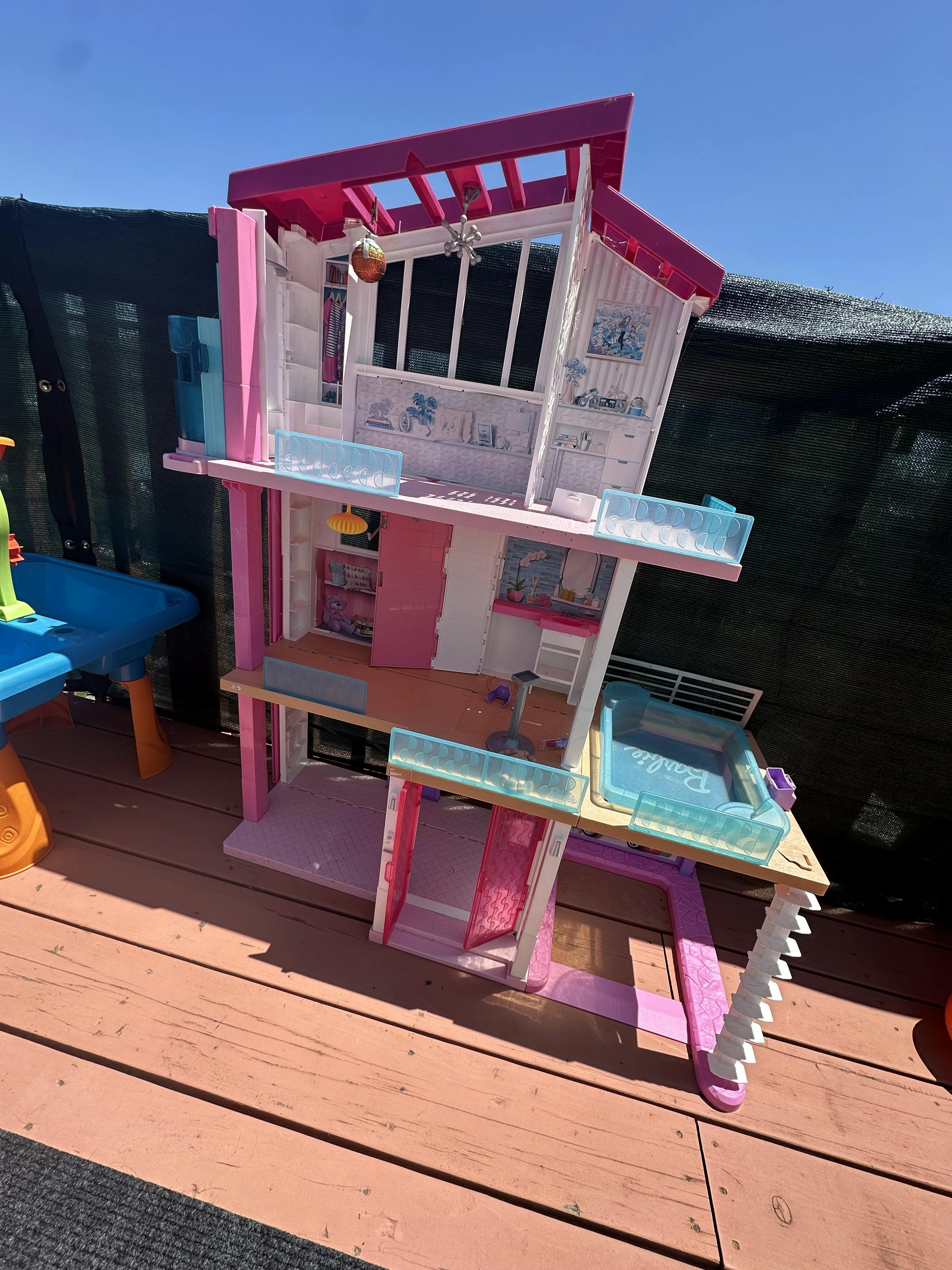 Multilevel toy dollhouse on a wooden deck