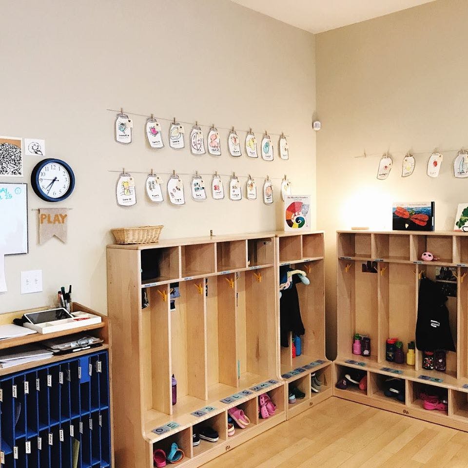 Classroom cubbies with shoes and coats, name tags on the wall
