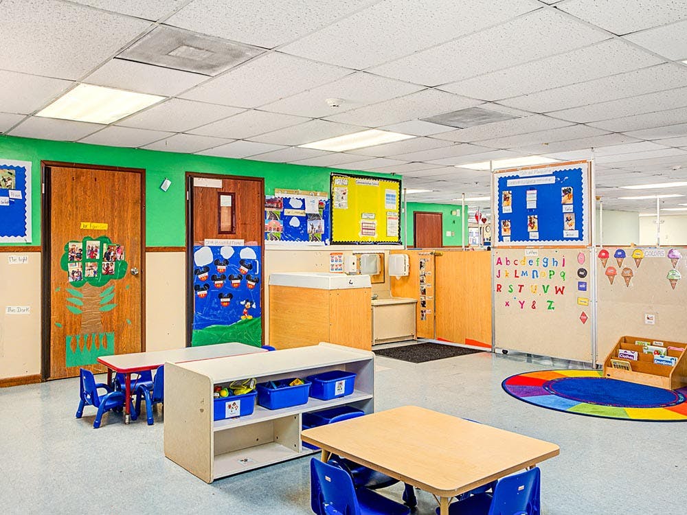 empty preschool classroom with small tables and chairs