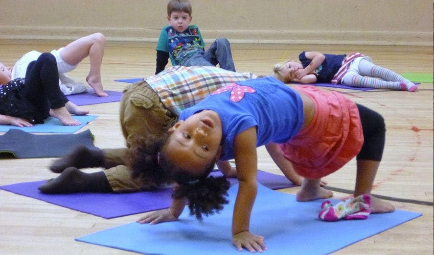 Children doing yoga poses on mats