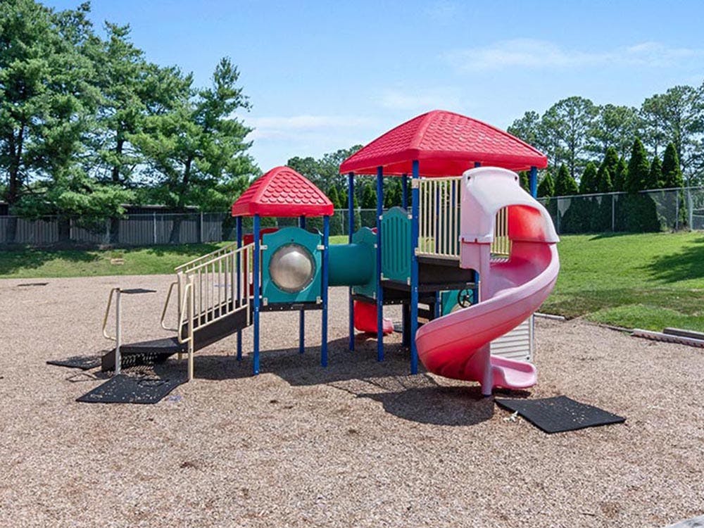 Colorful playground structure with a spiral slide on wood chips