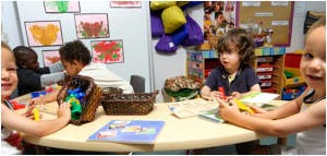 Children playing with toys at a table in a classroom