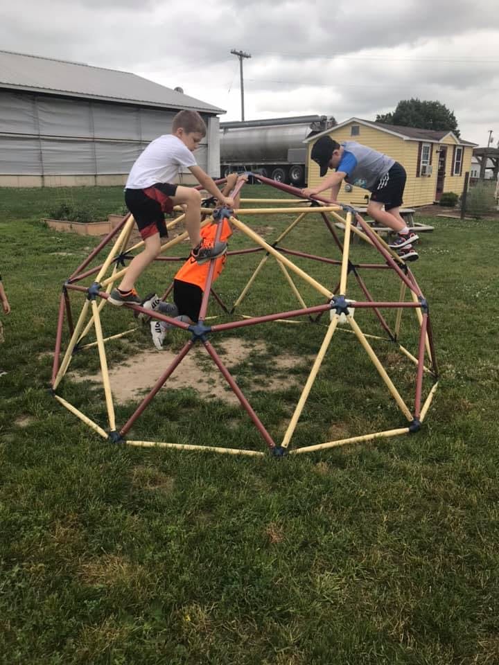 Three children climbing on a geodesic dome
