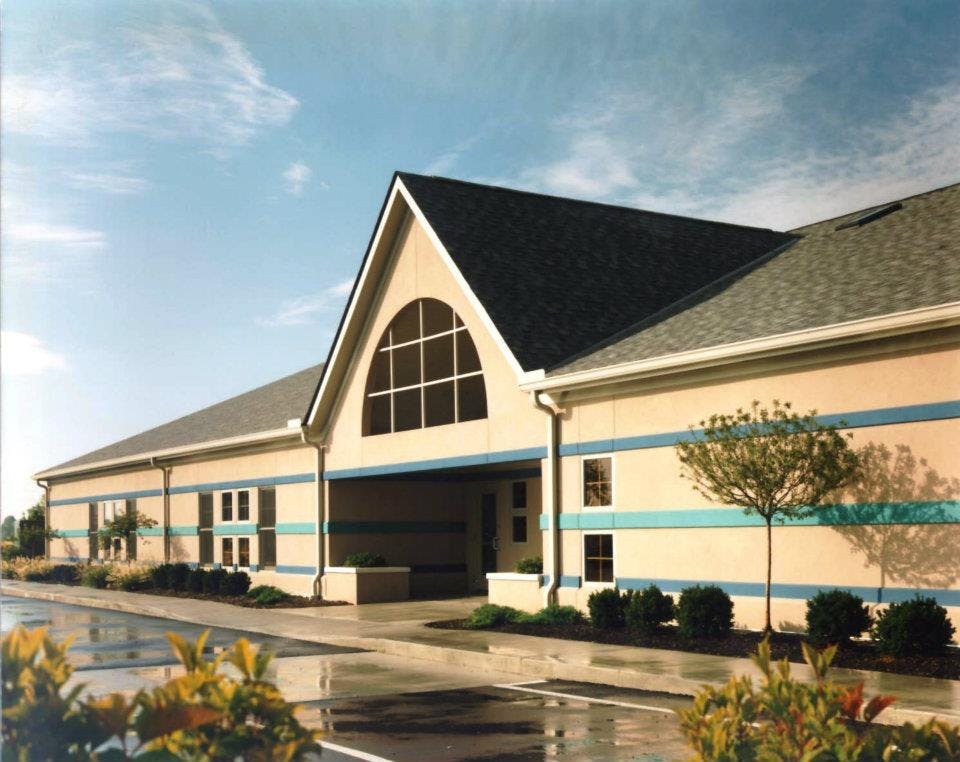 Exterior of a building with a large arched window and blue stripes