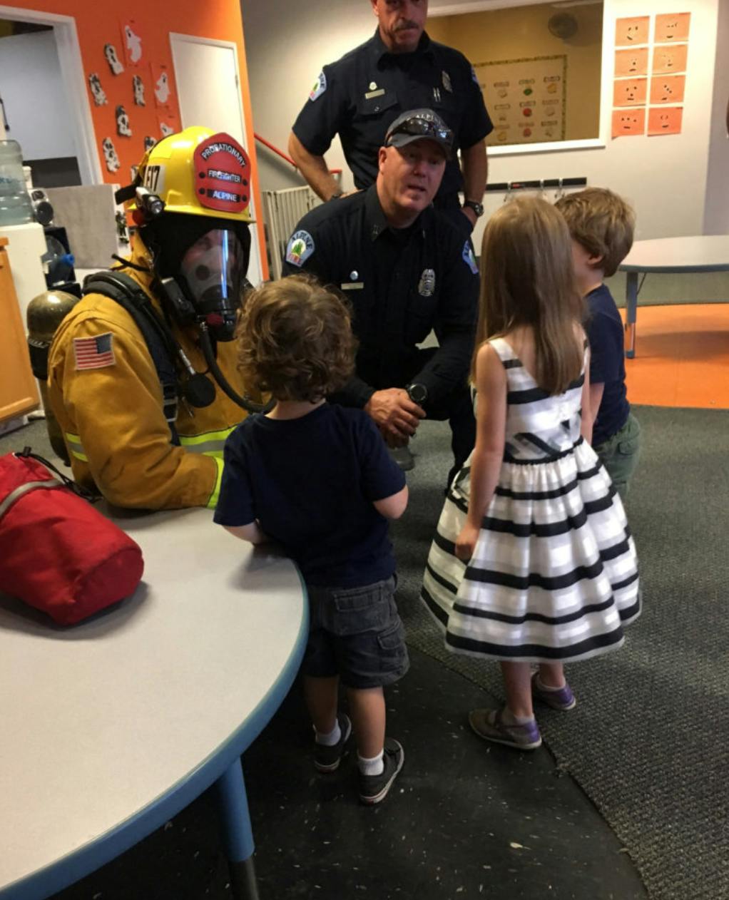 Firefighter and police officer interacting with children