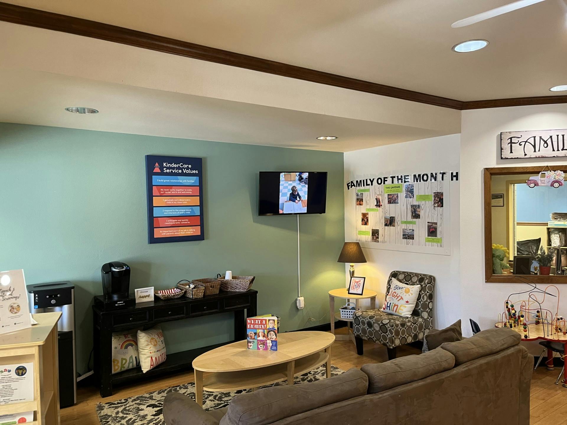 waiting room with a couch, armchair, side tables, and coffee station