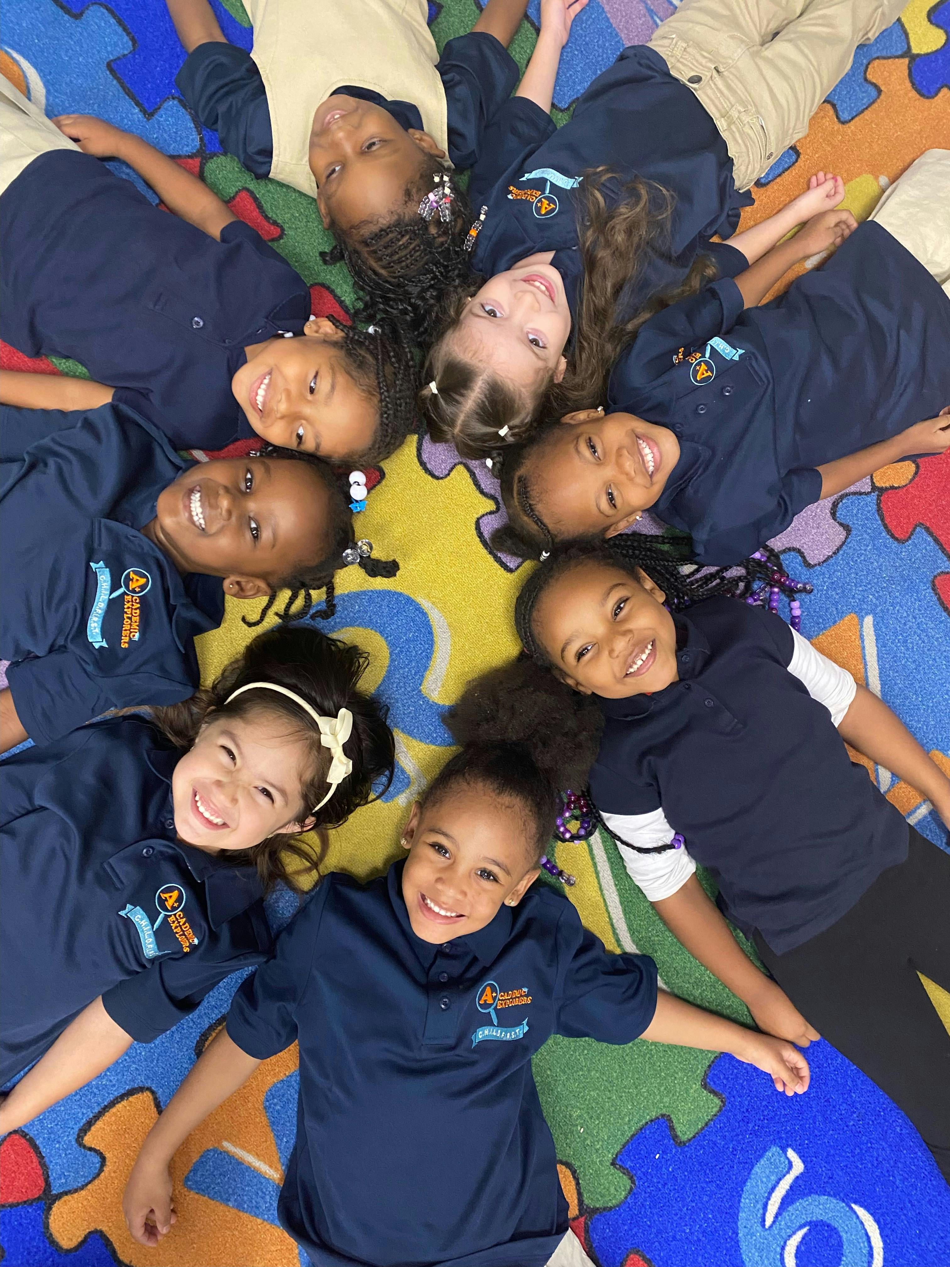 Group of children lying in a circle on a colorful puzzle mat