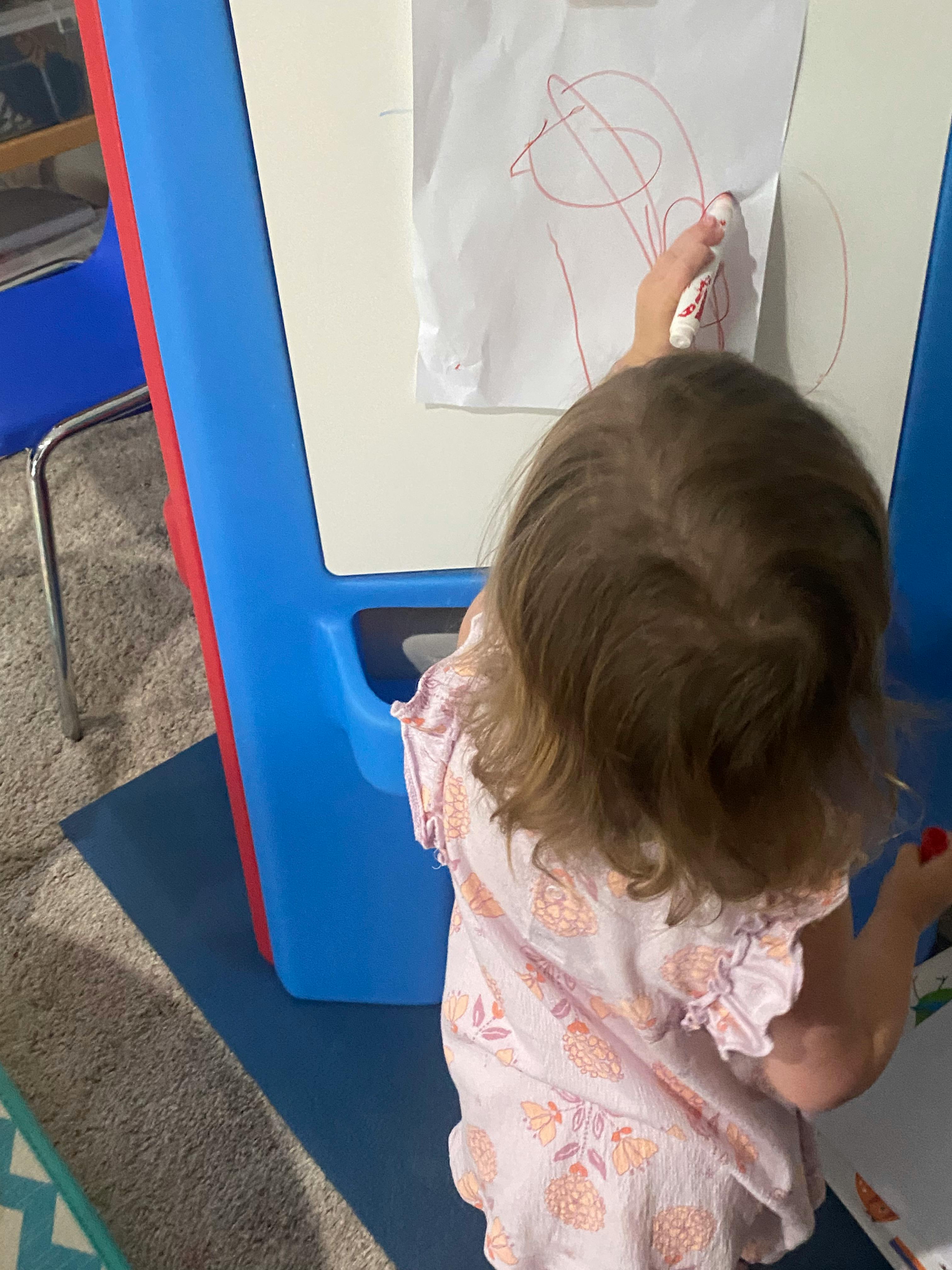 Child drawing on an easel
