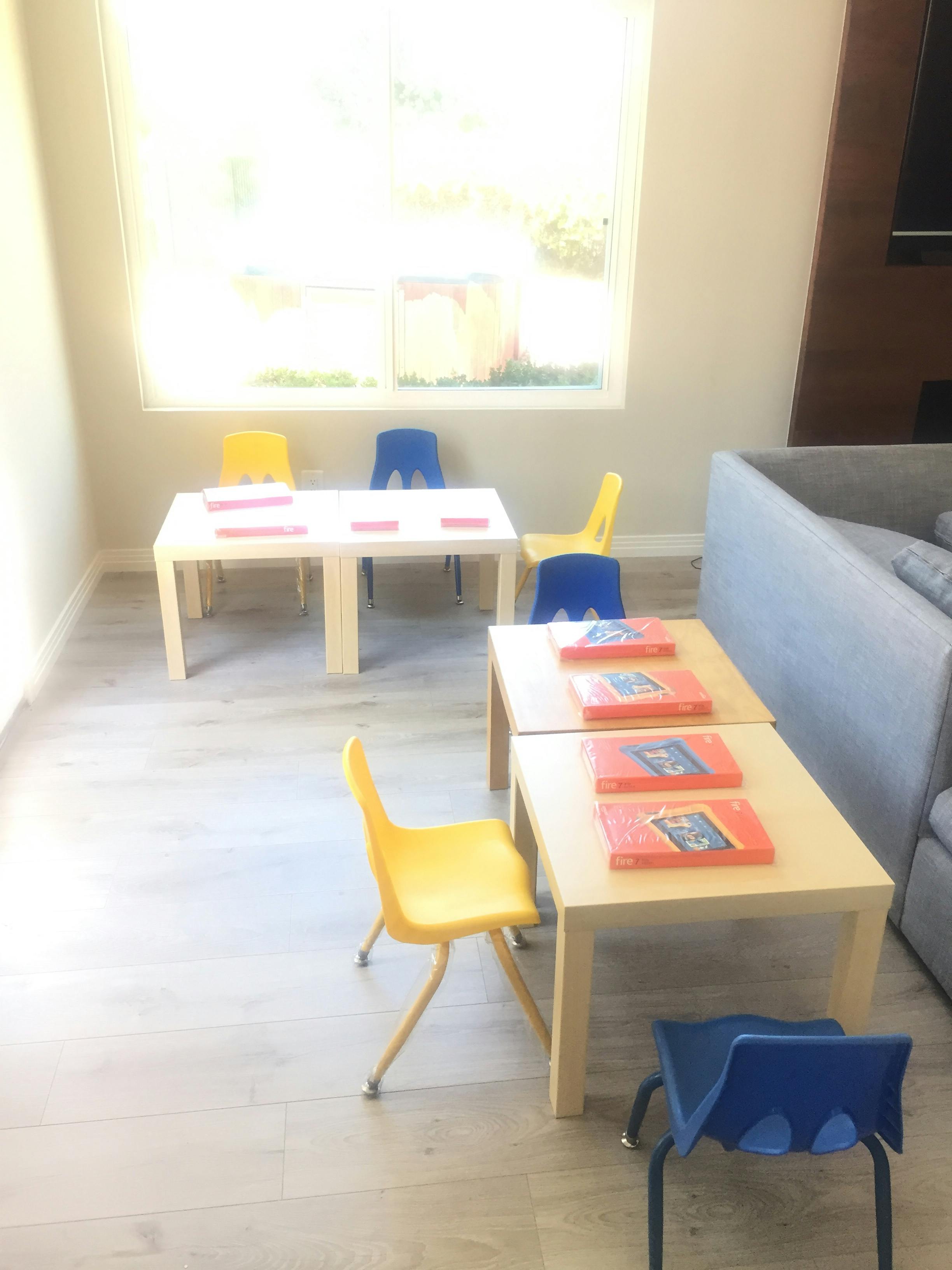 Small tables and chairs with books on top in a room
