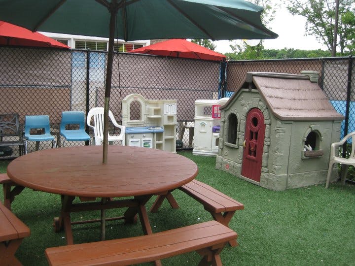 Outdoor play area with picnic table, umbrella, and playhouse