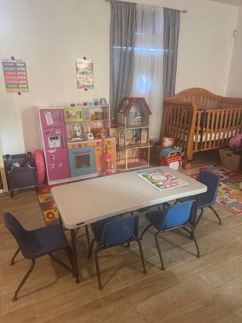 Playroom with a table and chairs, crib, and toy shelves