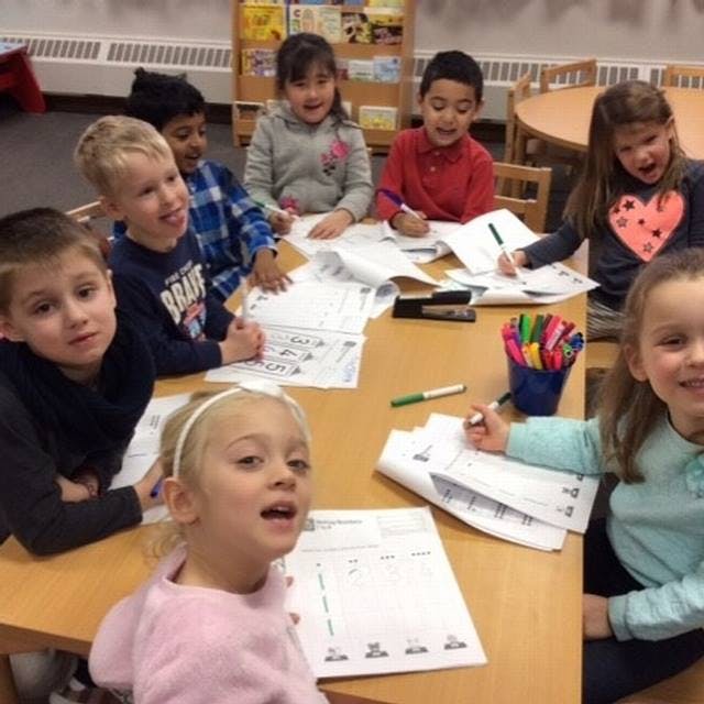 Children sitting at a table doing schoolwork