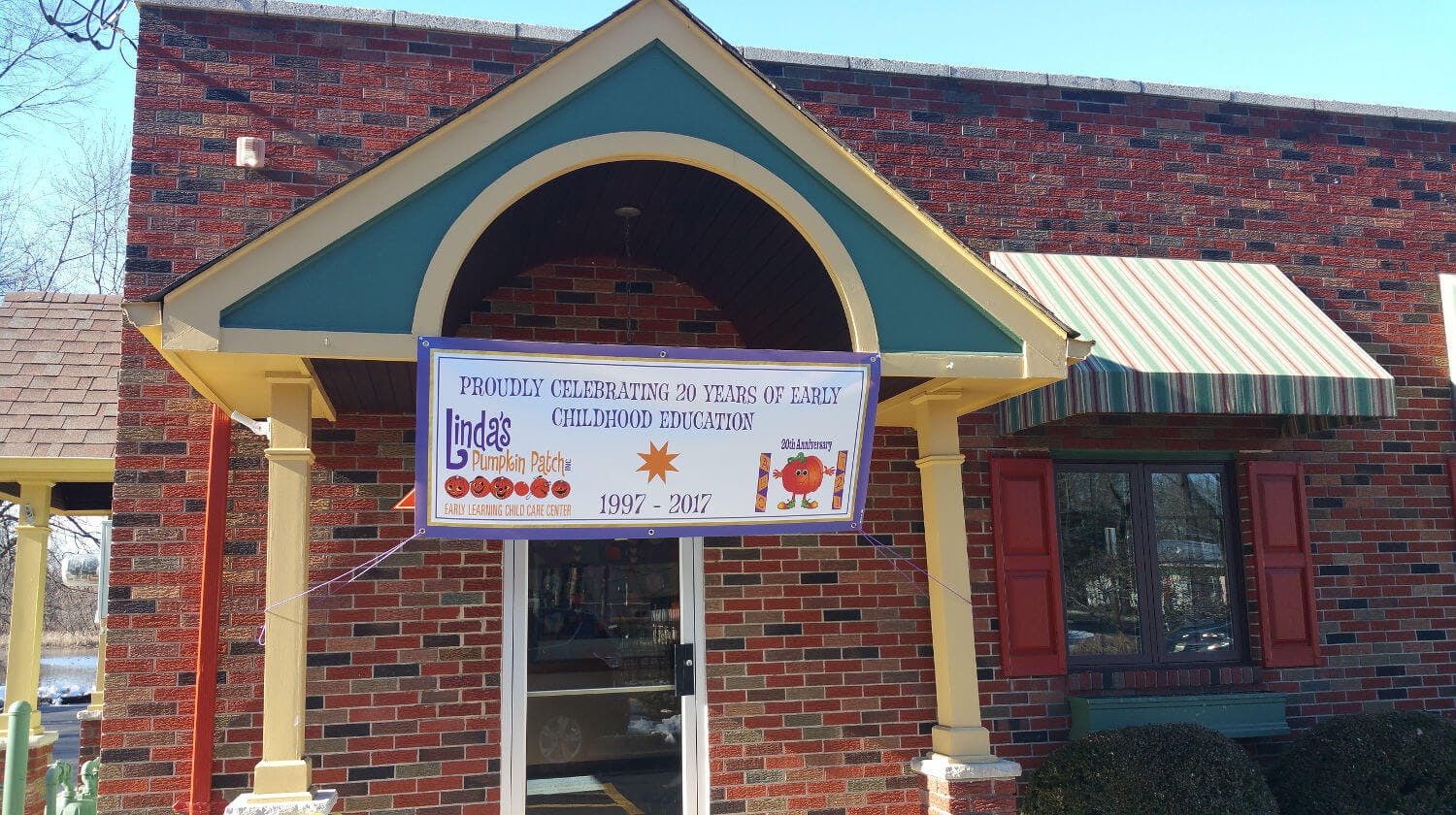 Building entrance with a sign that reads "Play and Learn Children's Museum"