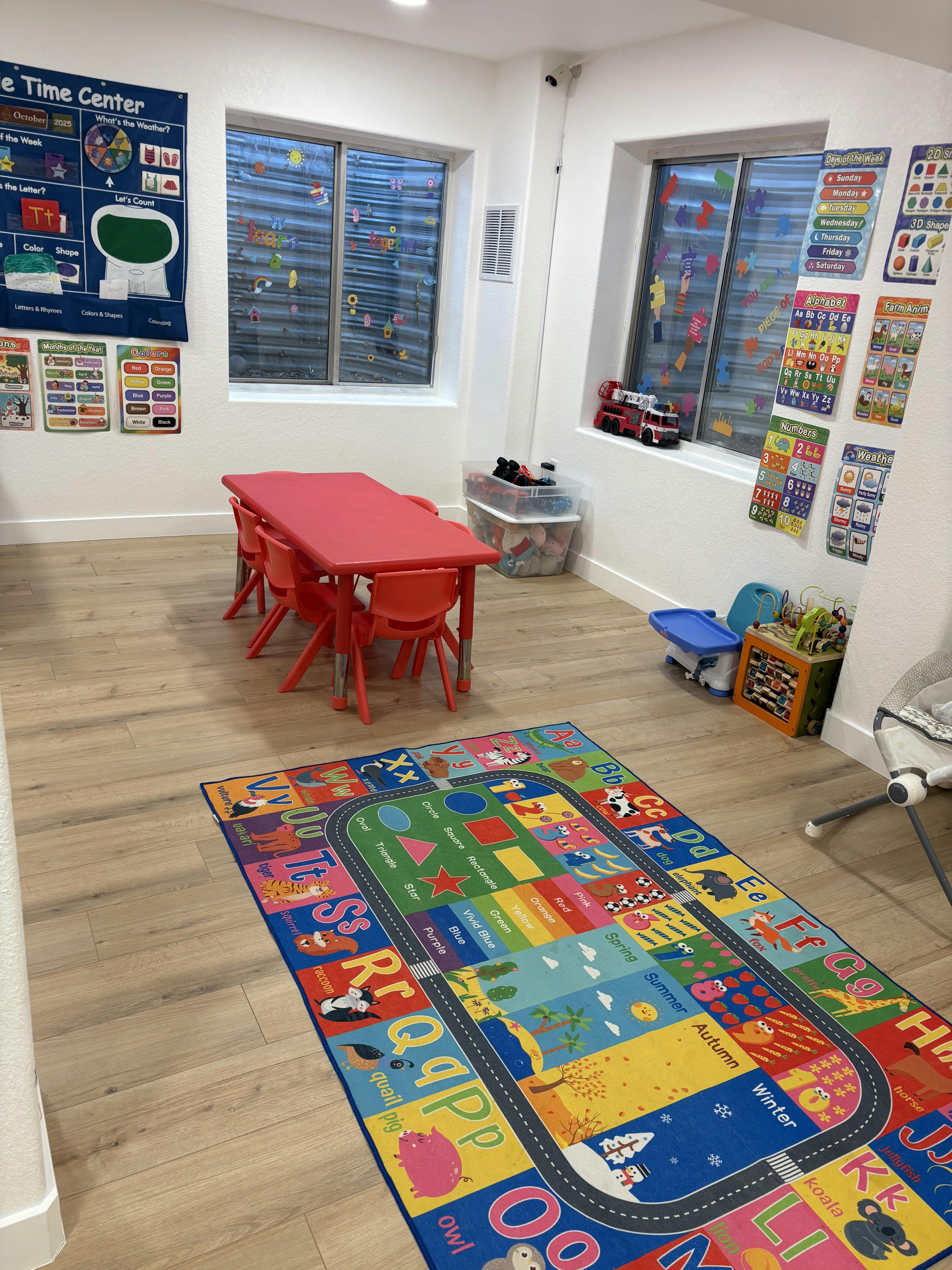 Colorful preschool classroom with a small table, chairs, and learning rug