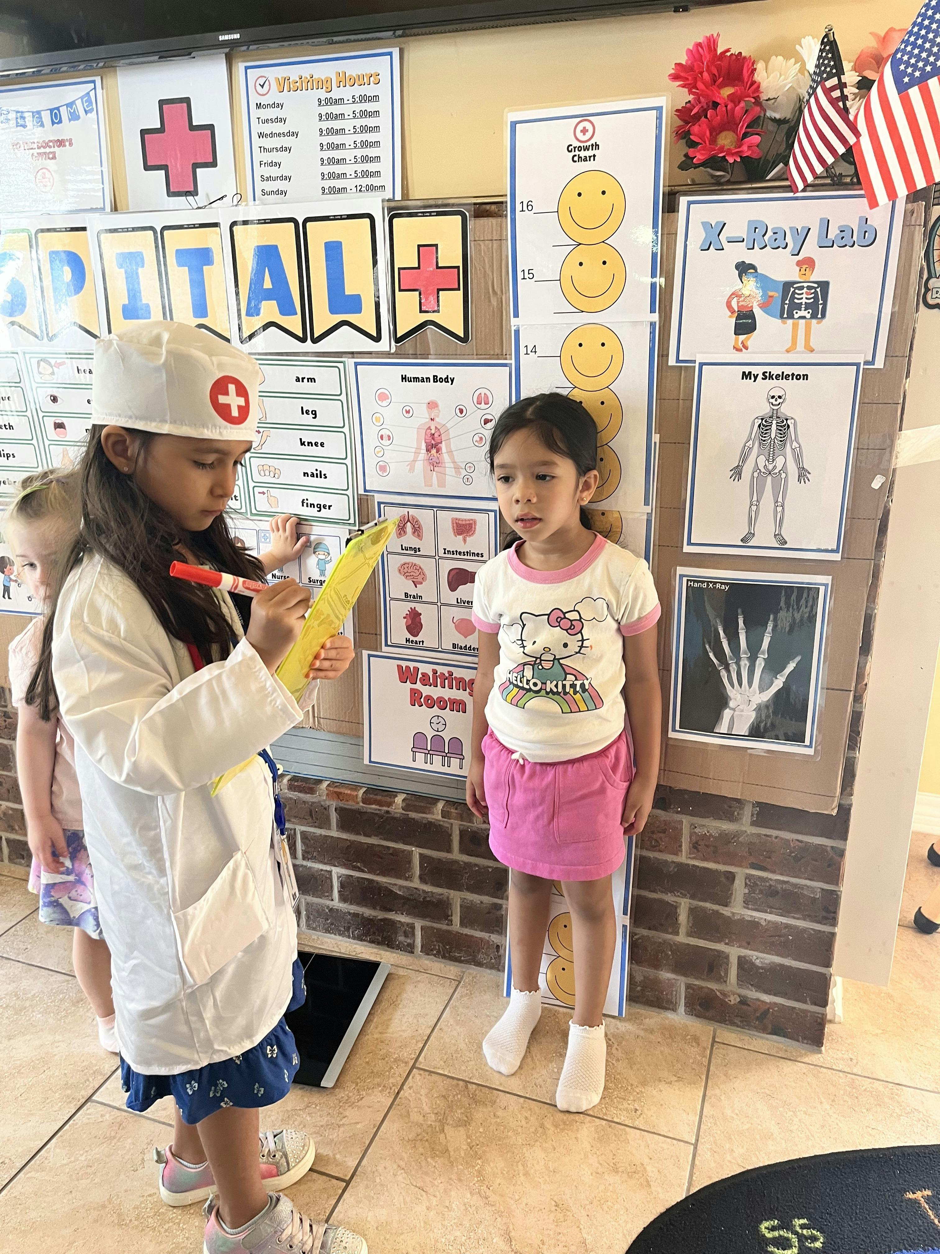 Child in doctor costume writing on a clipboard, another child standing nearby