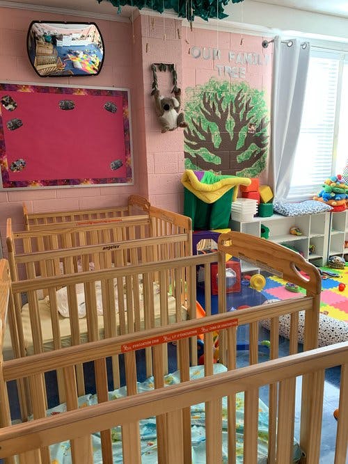 Multiple wooden cribs in a room with colorful decor