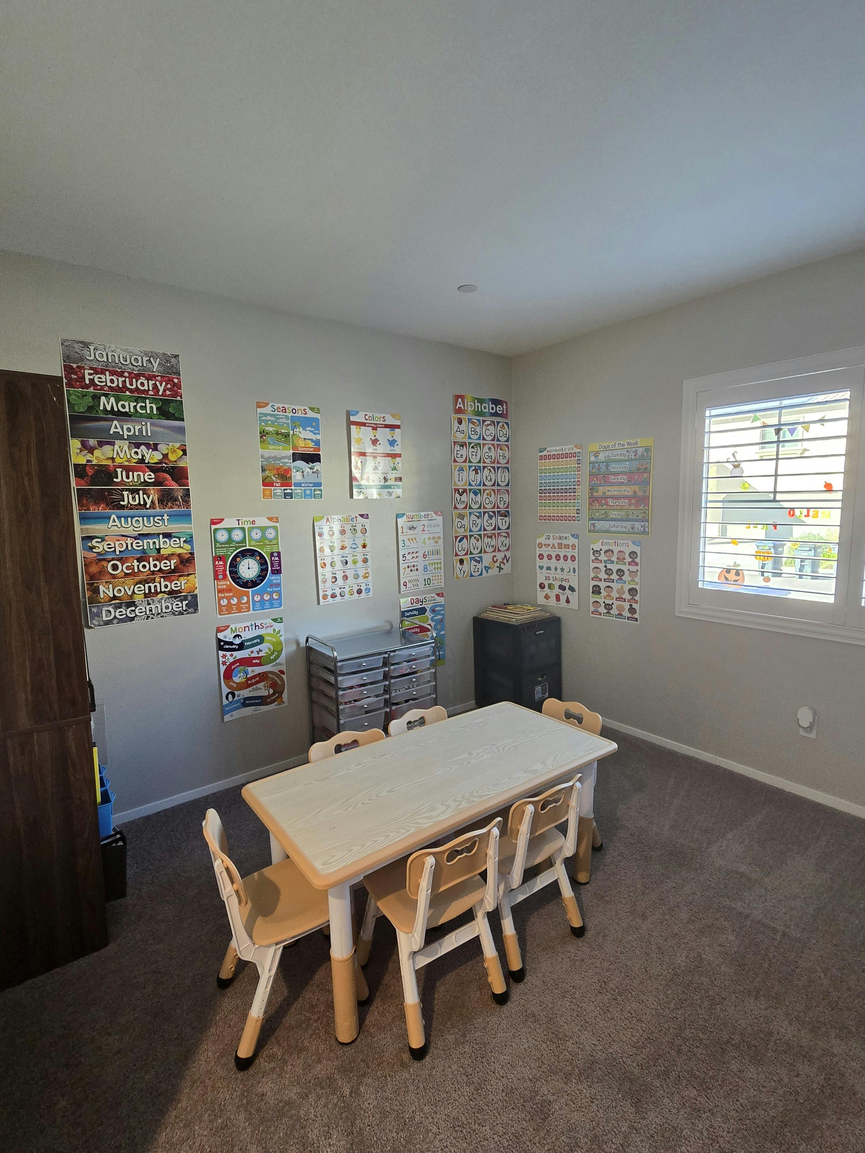 Classroom with a table and chairs, educational posters on the walls