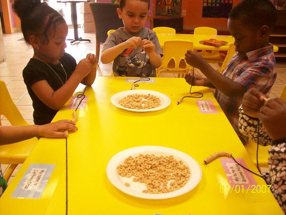 Children making necklaces with cereal