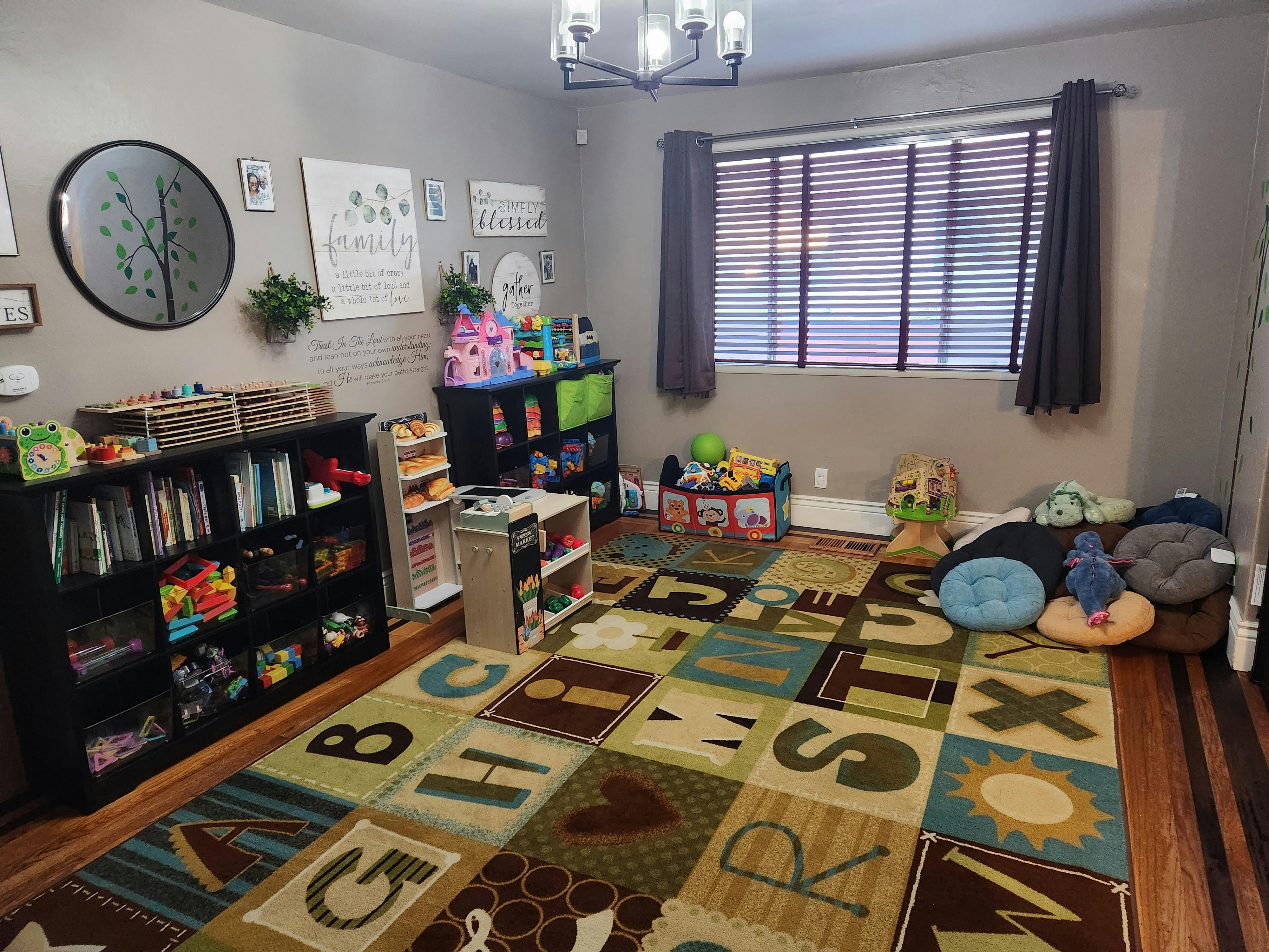 Playroom with alphabet rug, bookshelves, and toys