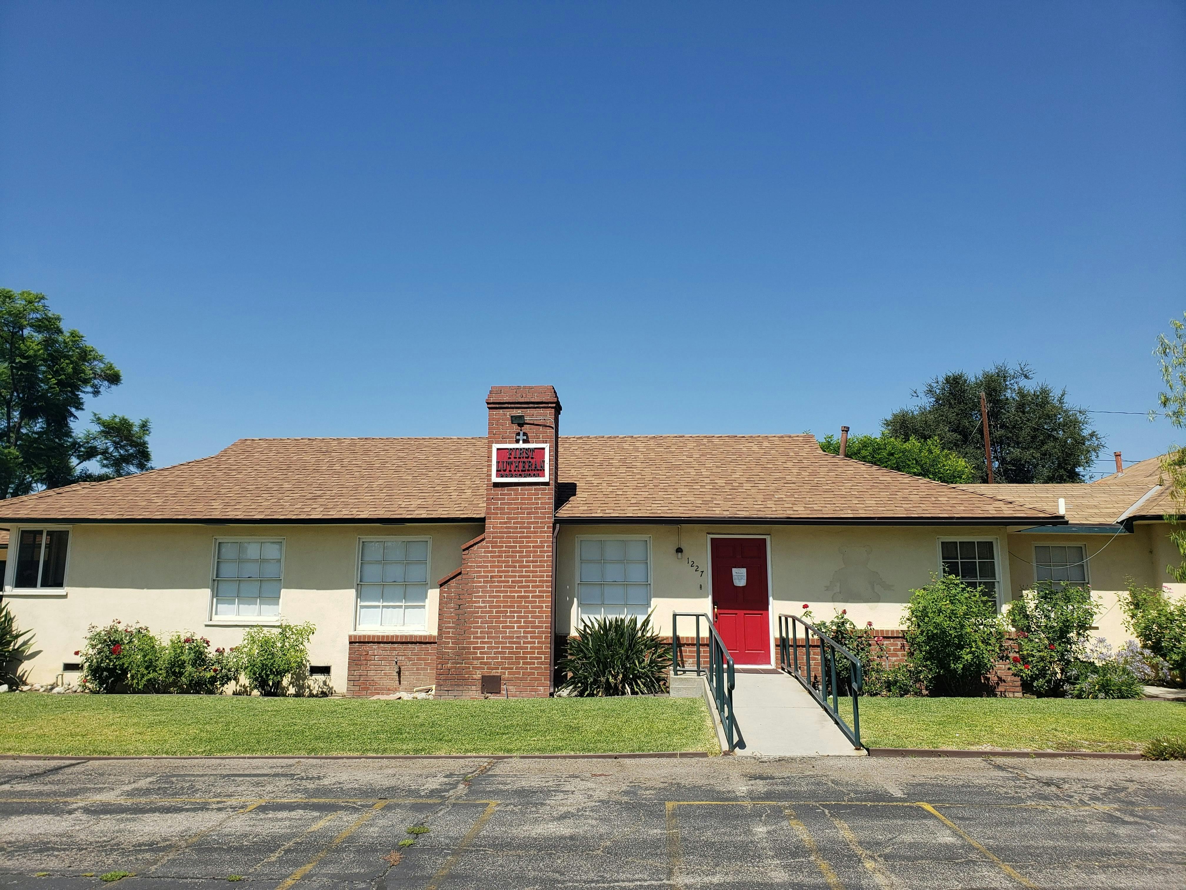 Single-story building with a red door and a ramp leading ramp