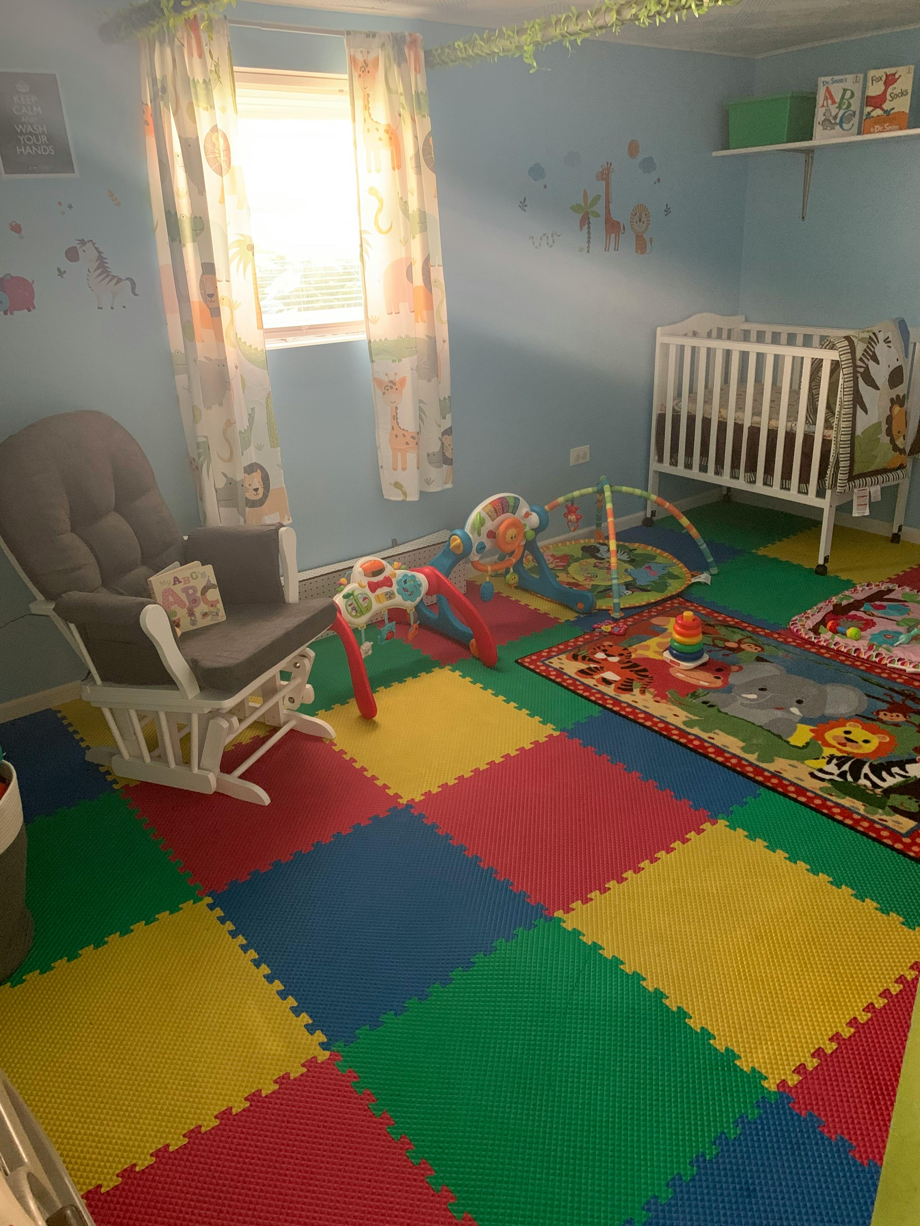 Nursery room with a crib, rocking chair, and colorful play mats
