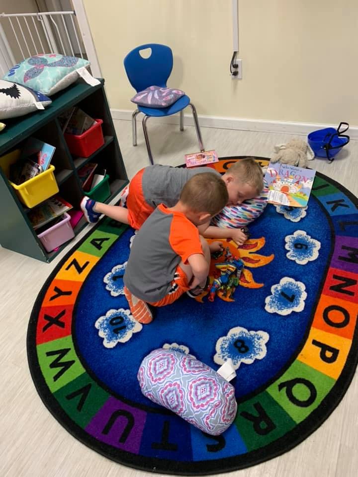 Two children playing on an alphabet rug