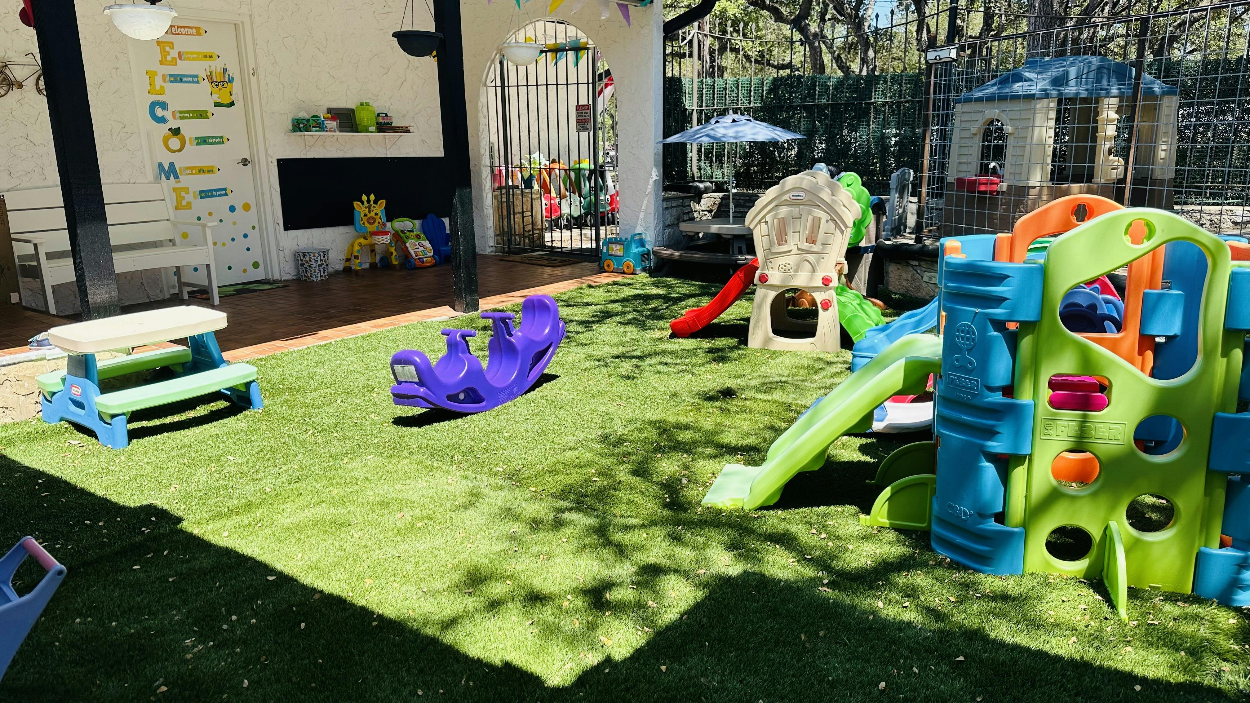 Outdoor playground with green turf, slides, and play structures