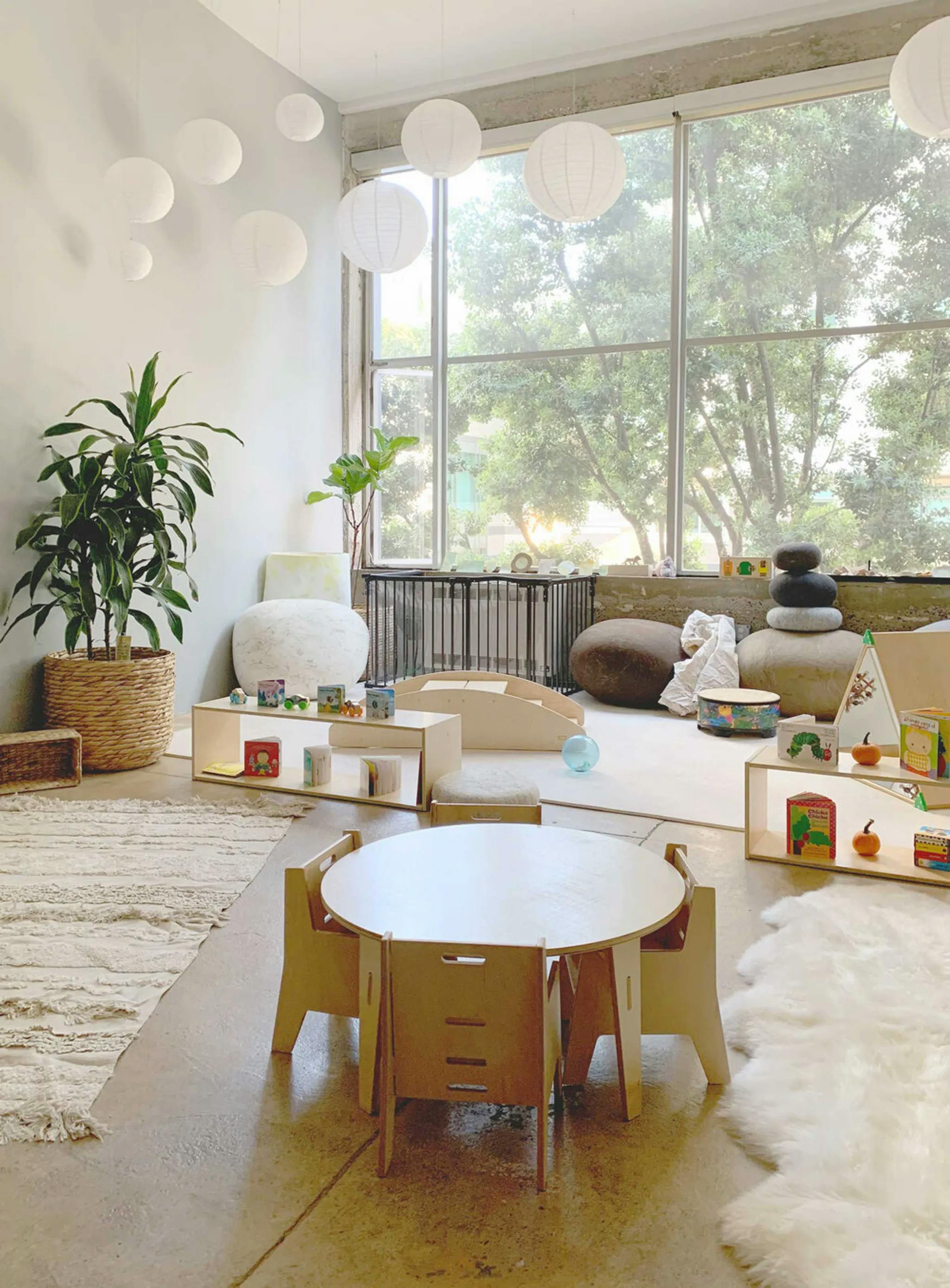 Children's play area with small table and chairs, shelves, and large window