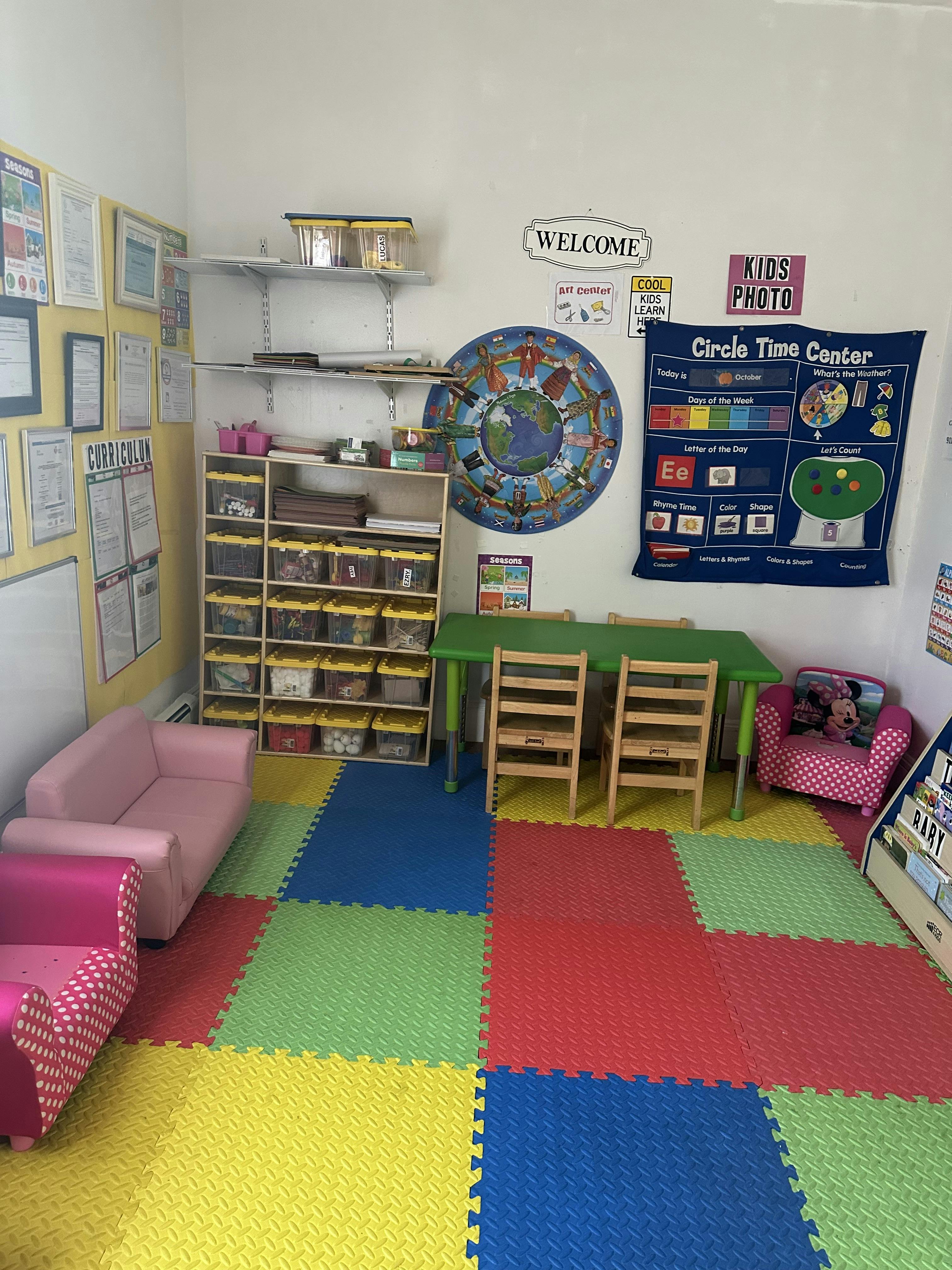 Classroom with colorful floor mats, small table and chairs, and shelves