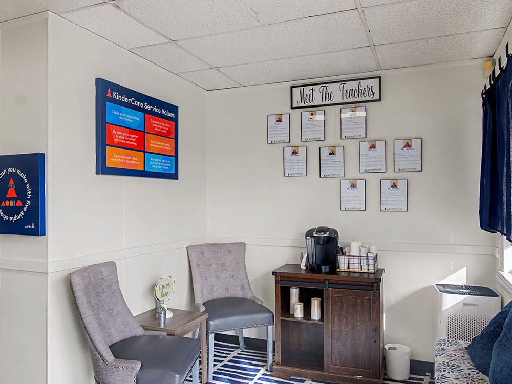 Lobby area with a "KinderCare Service Values" sign and "Meet The Teachers" display
