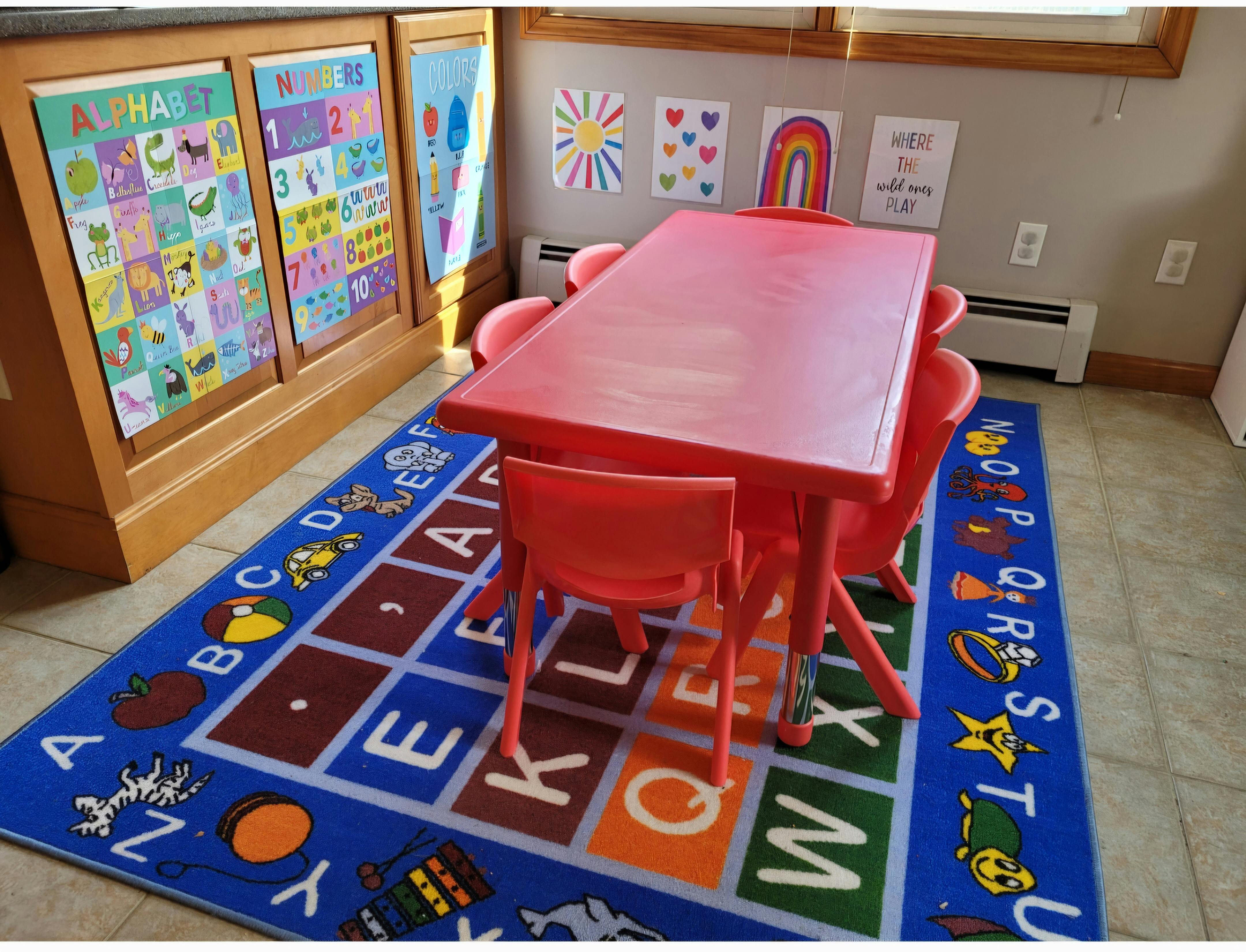 Red table and chairs on an alphabet rug in a classroom