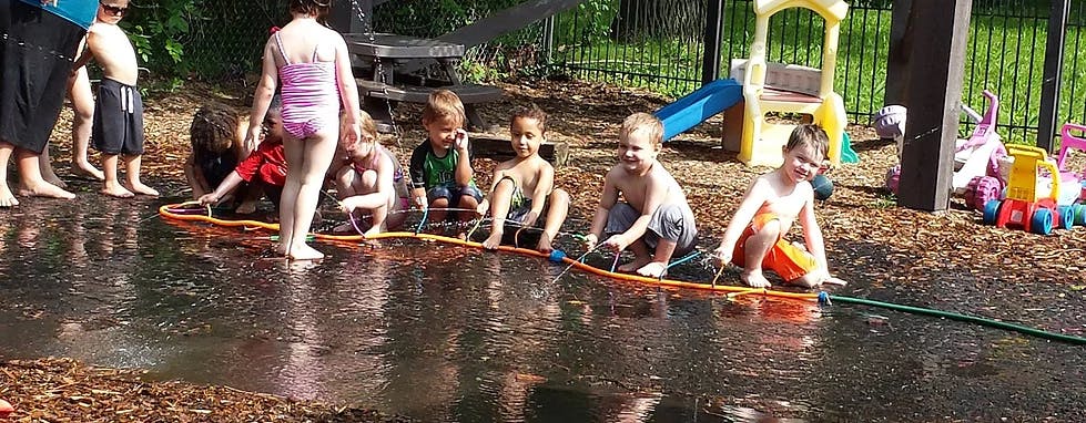 Children playing in water from a hose