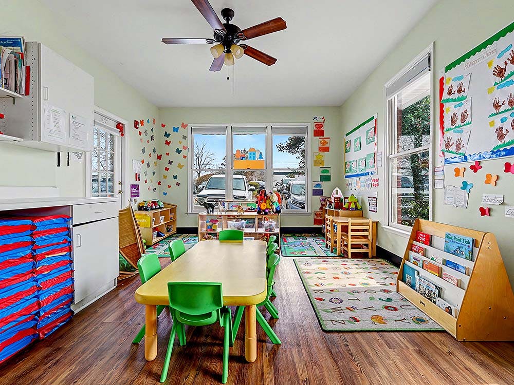 Children's classroom with small tables, chairs, and books