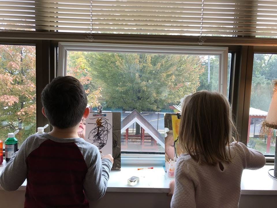 Two children looking out a window
