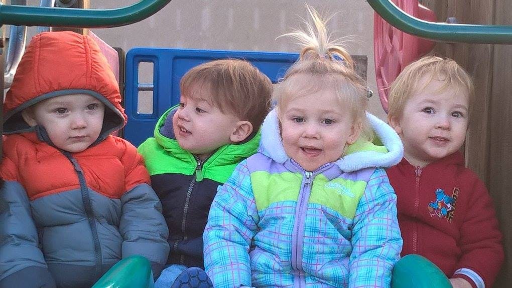Four children in winter coats sitting together