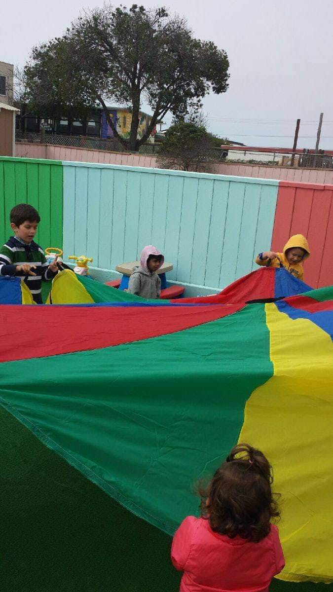 Children playing with a colorful parachute