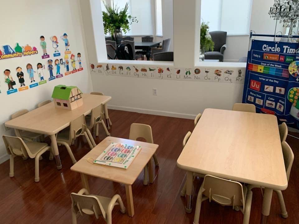 Classroom with small tables and chairs, wall decorations, and a "Circle Time" chart