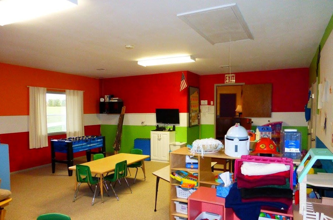 Colorful room with tables, chairs, and play equipment