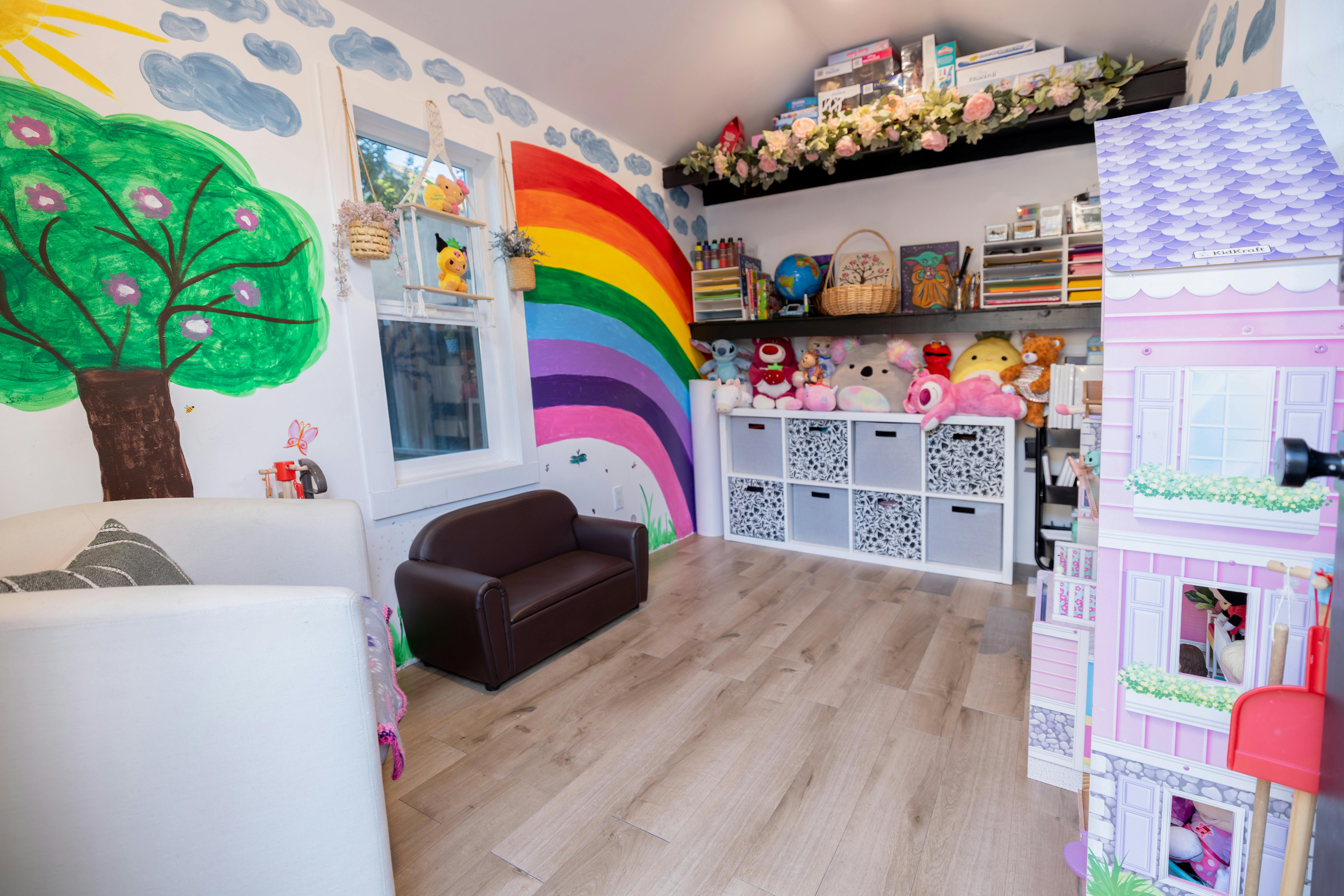 Playroom with mural, toy storage, and large dollhouse