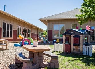 Outdoor play area with a small picnic table and playhouse