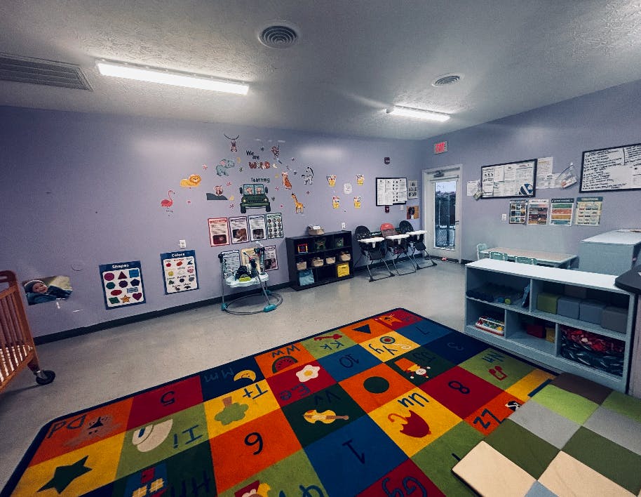 Classroom interior with educational wall decorations and a colorful alphabet rug