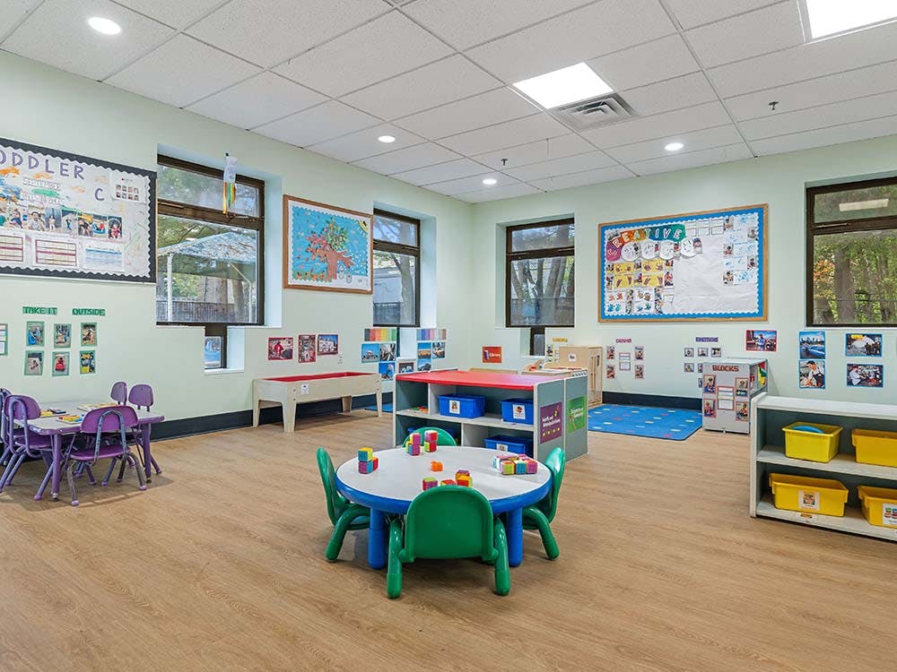 A colorful classroom with small tables and chairs for children