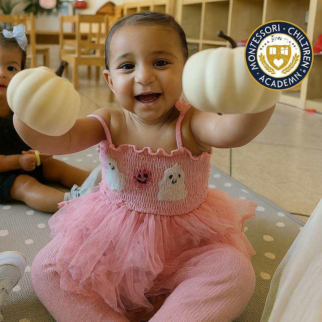 Child in pink dress holding two small white pumpkins