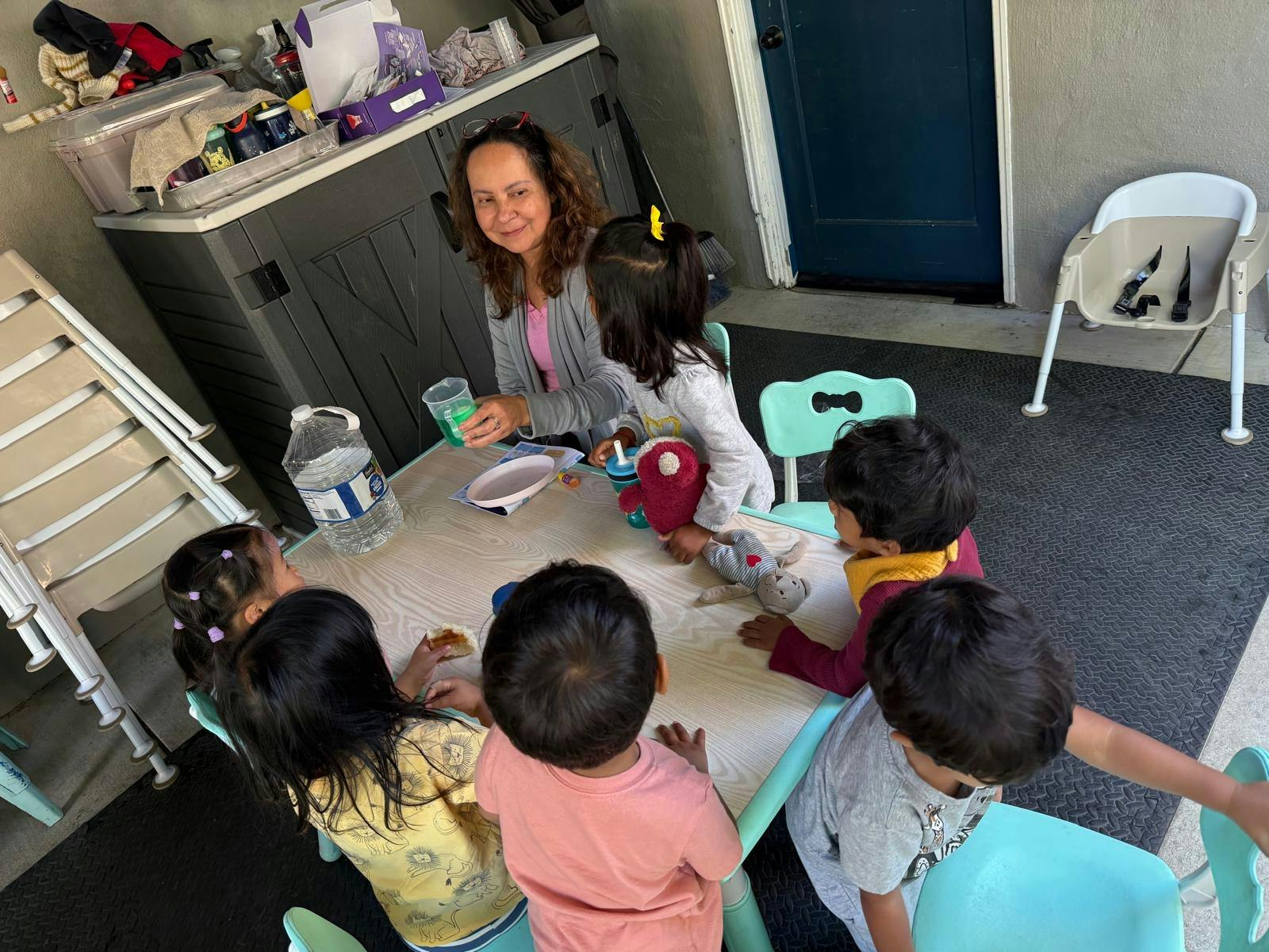 Adult person with four young children around a table