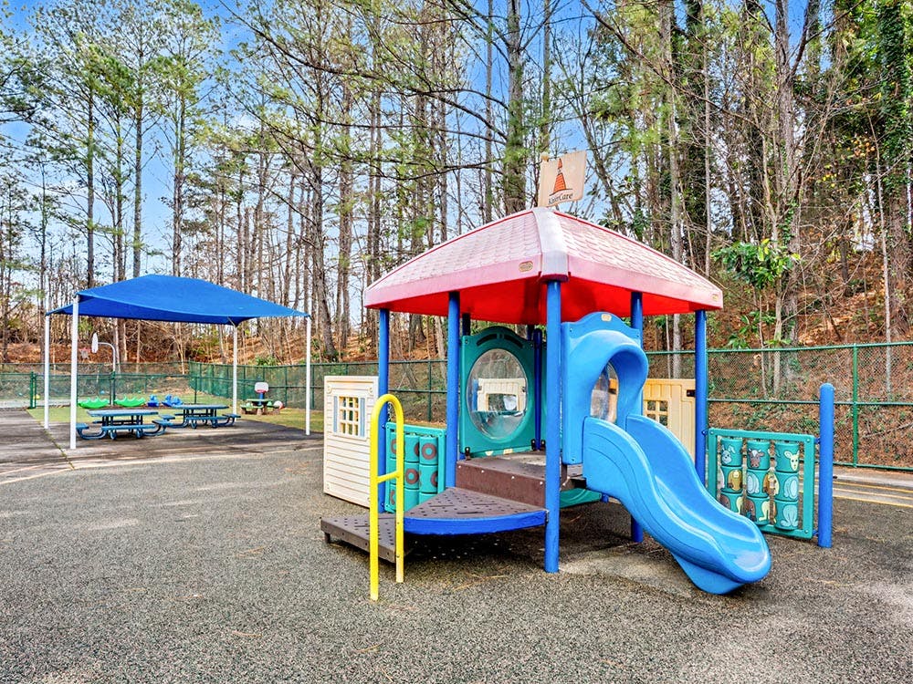 A colorful playground with slides and a covered seating area