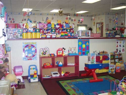 Playroom with toys on shelves and a colorful rug
