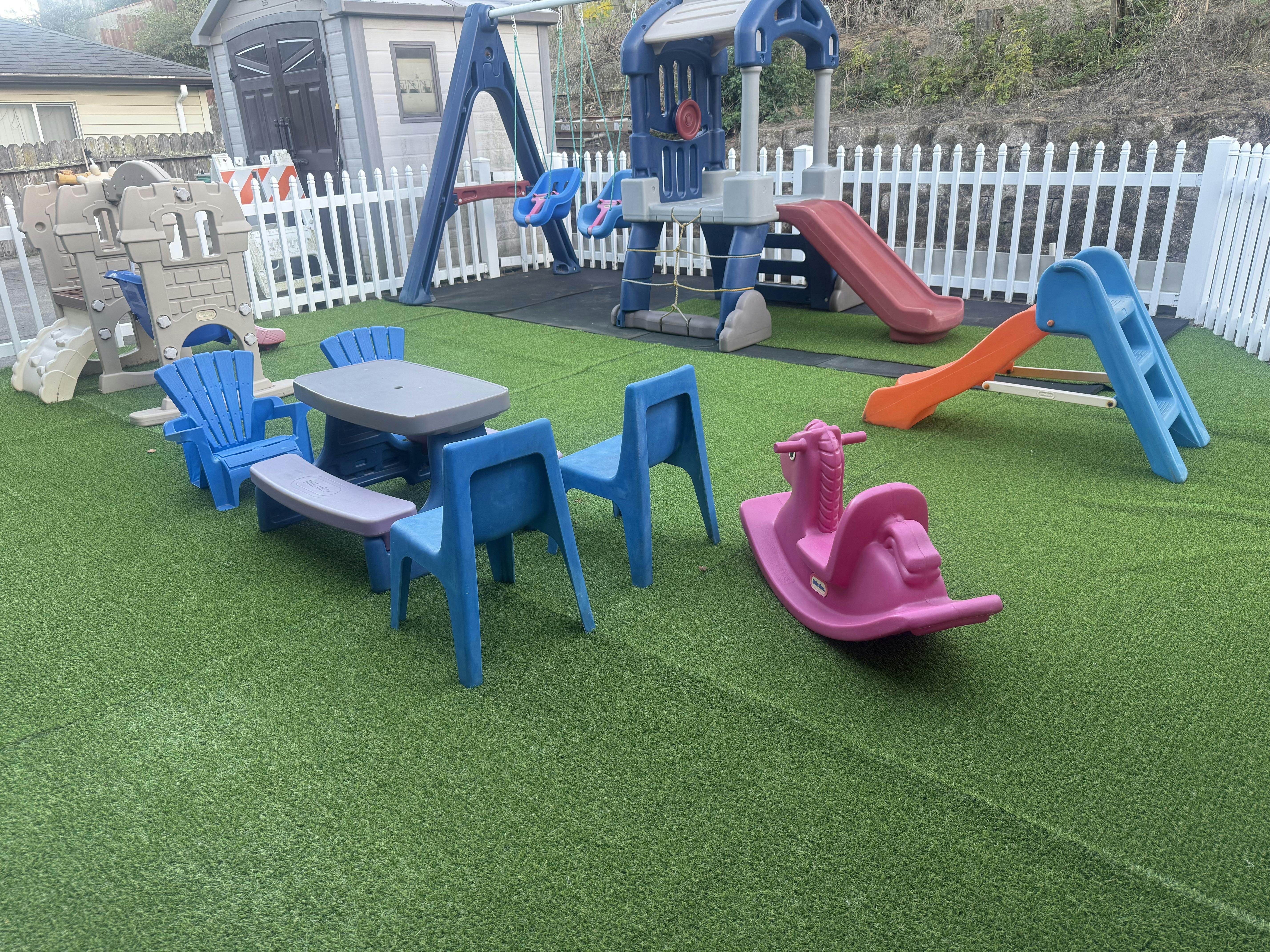 Children's playground with slides, swings, and a plastic table with chairs